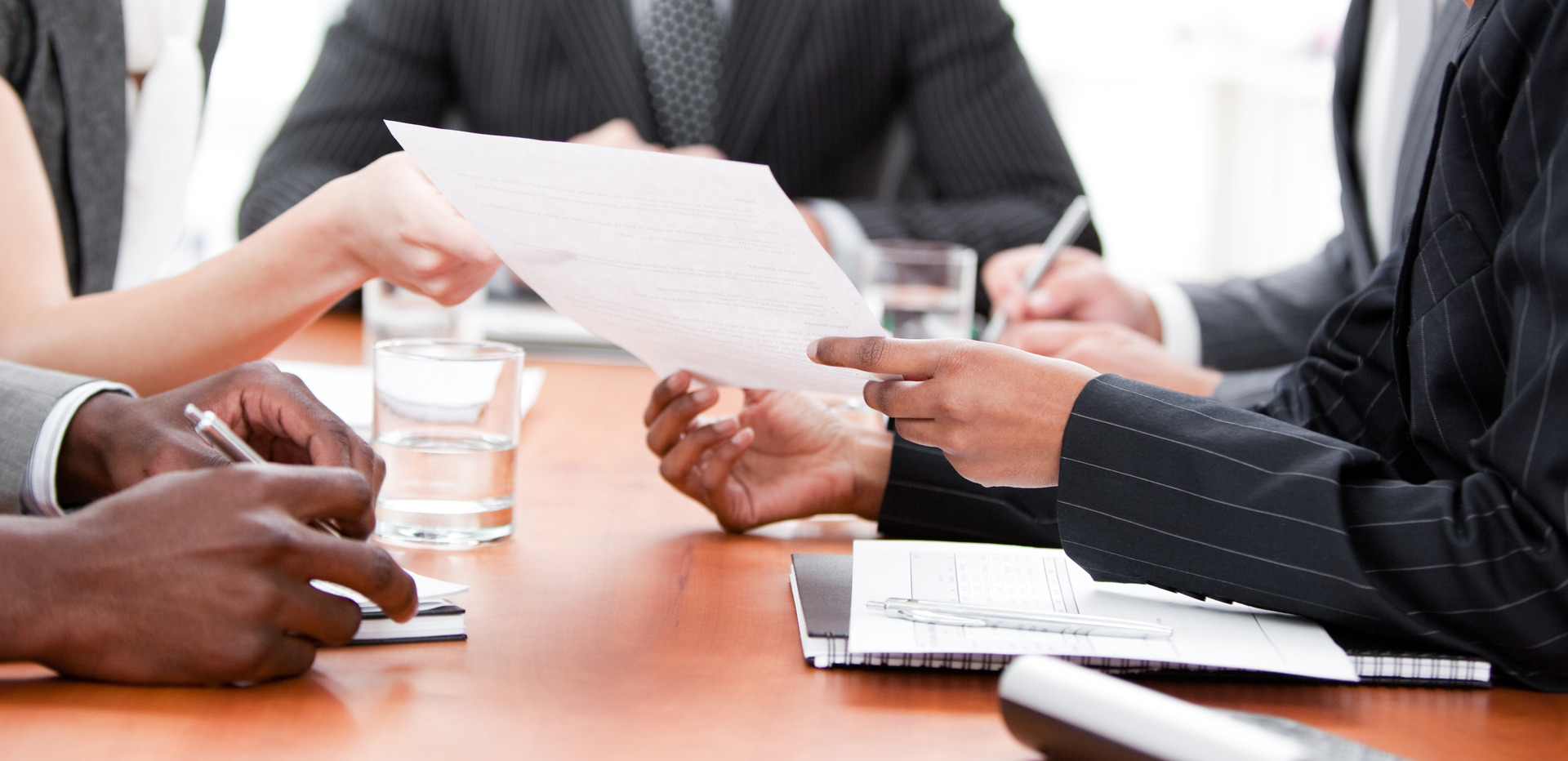 A group of business people sitting around a table discussing constitutional rights and charges.