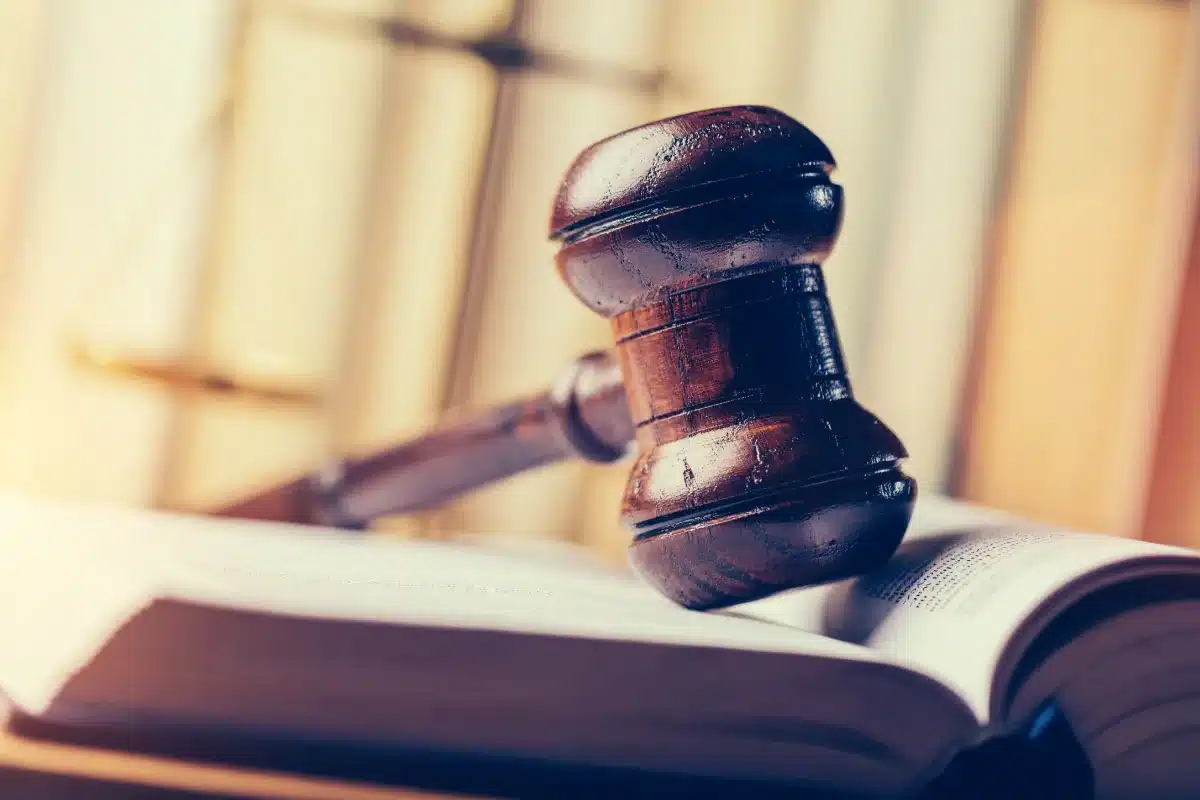 A lawyer's gavel rests on top of an open book.