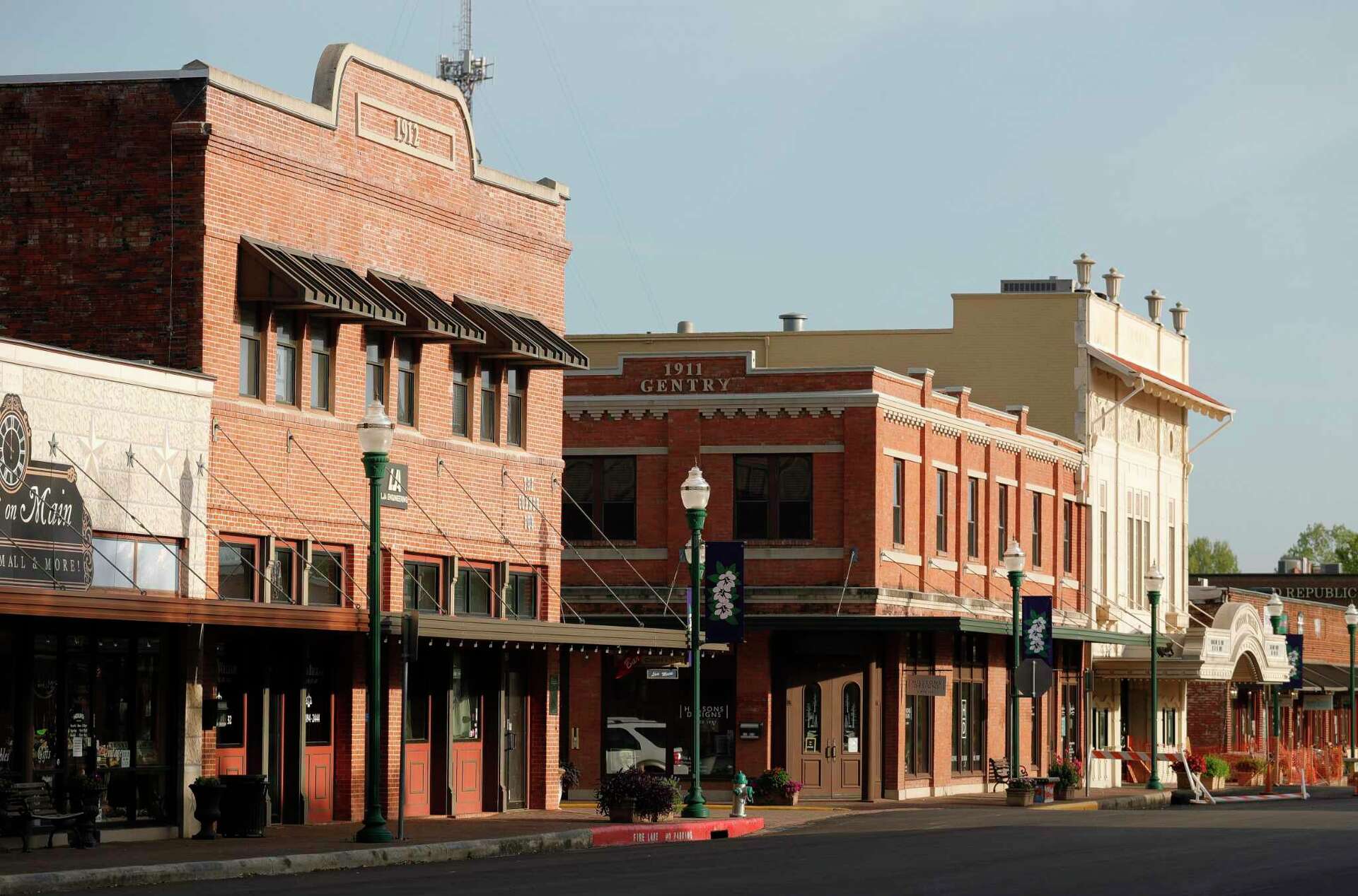 Historic downtown street with brick buildings, including the Gentry building from 1911, green lampposts lining the sidewalk, and a nearby Conroe expungement lawyer offering legal assistance.